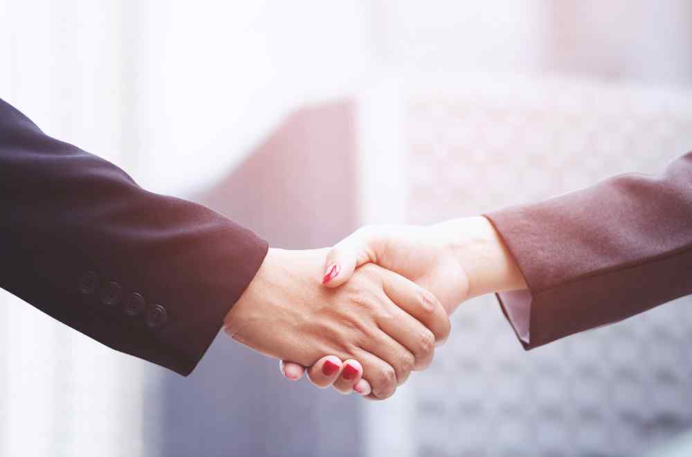 Two people shaking hands at the end of a job negotiation