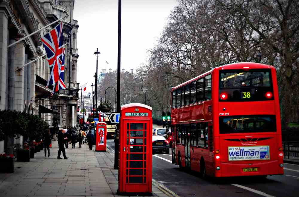 Black and white image of a London street with the Union Flag, telephone box and London double decker bus picked out in full colour, to signify New Zealand qualified lawyers in London