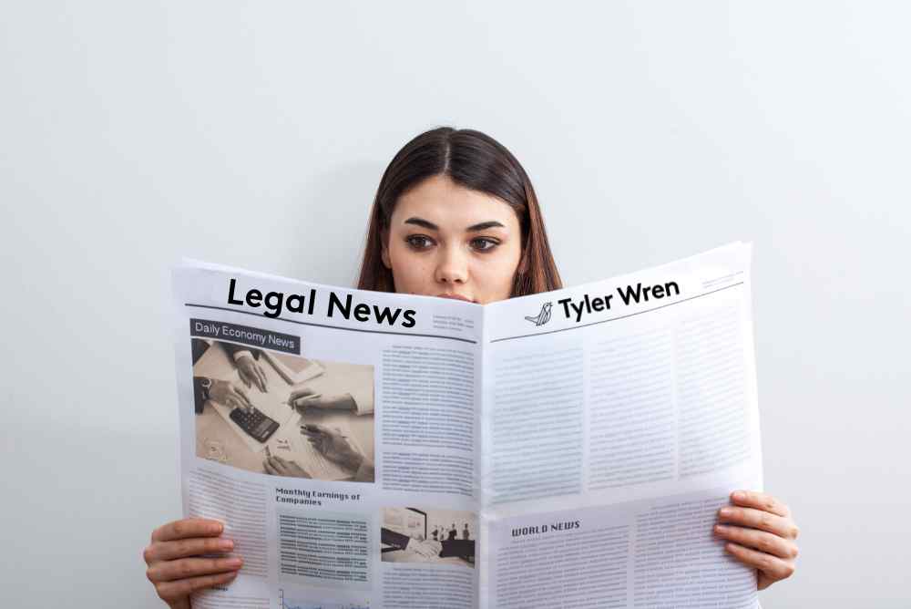 A woman sits in front of a white wall reading a broadsheet newspaper with the words "legal news" and "Tyler Wren" as headlines, representing an overview of legal jobs for 2023