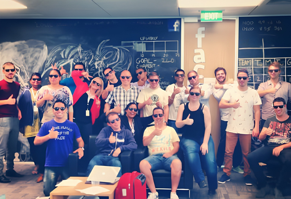 Teletech team posing in the office with Facebook branding visible in the background in 2012